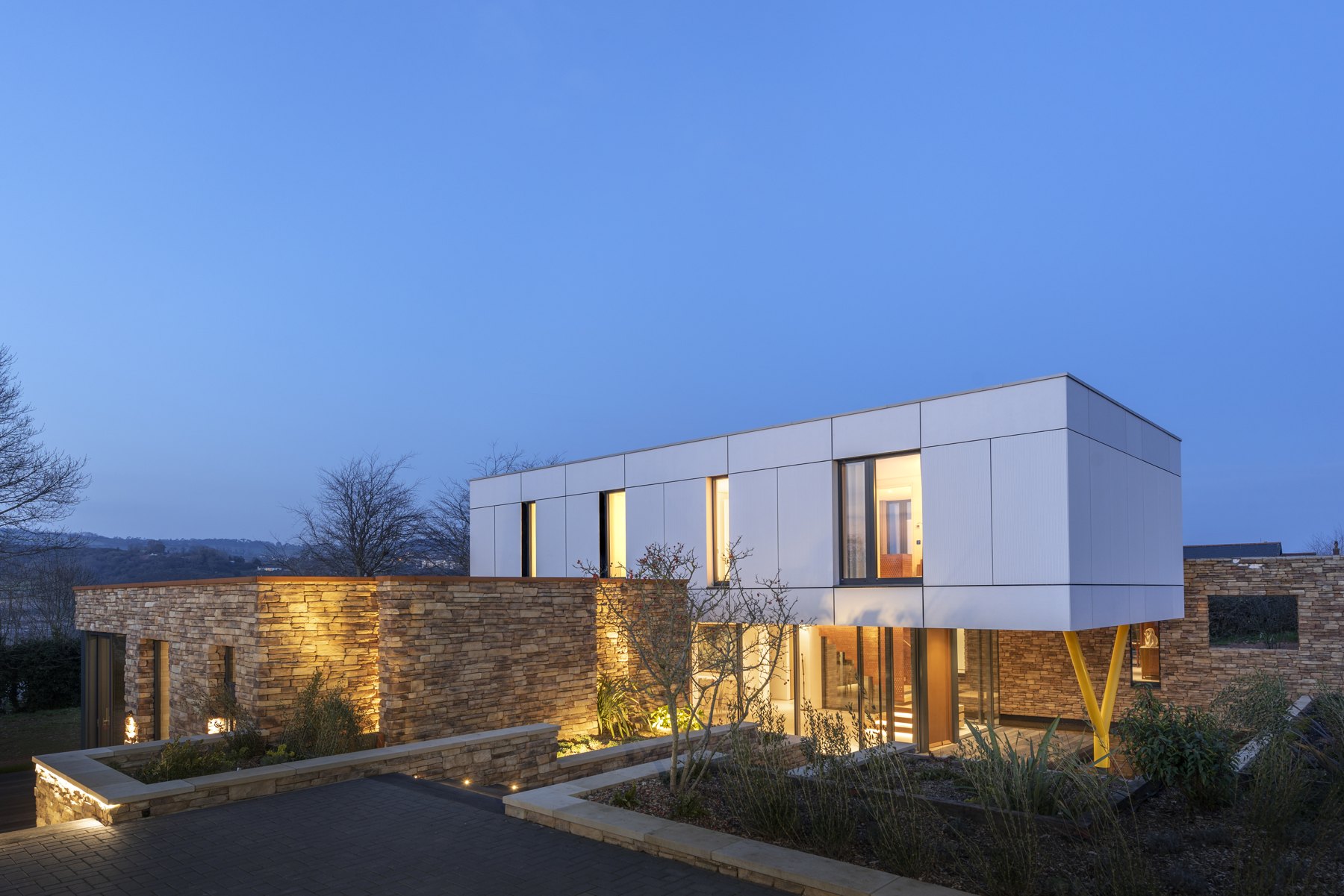 Contemporary home exterior with illuminated windows at dusk