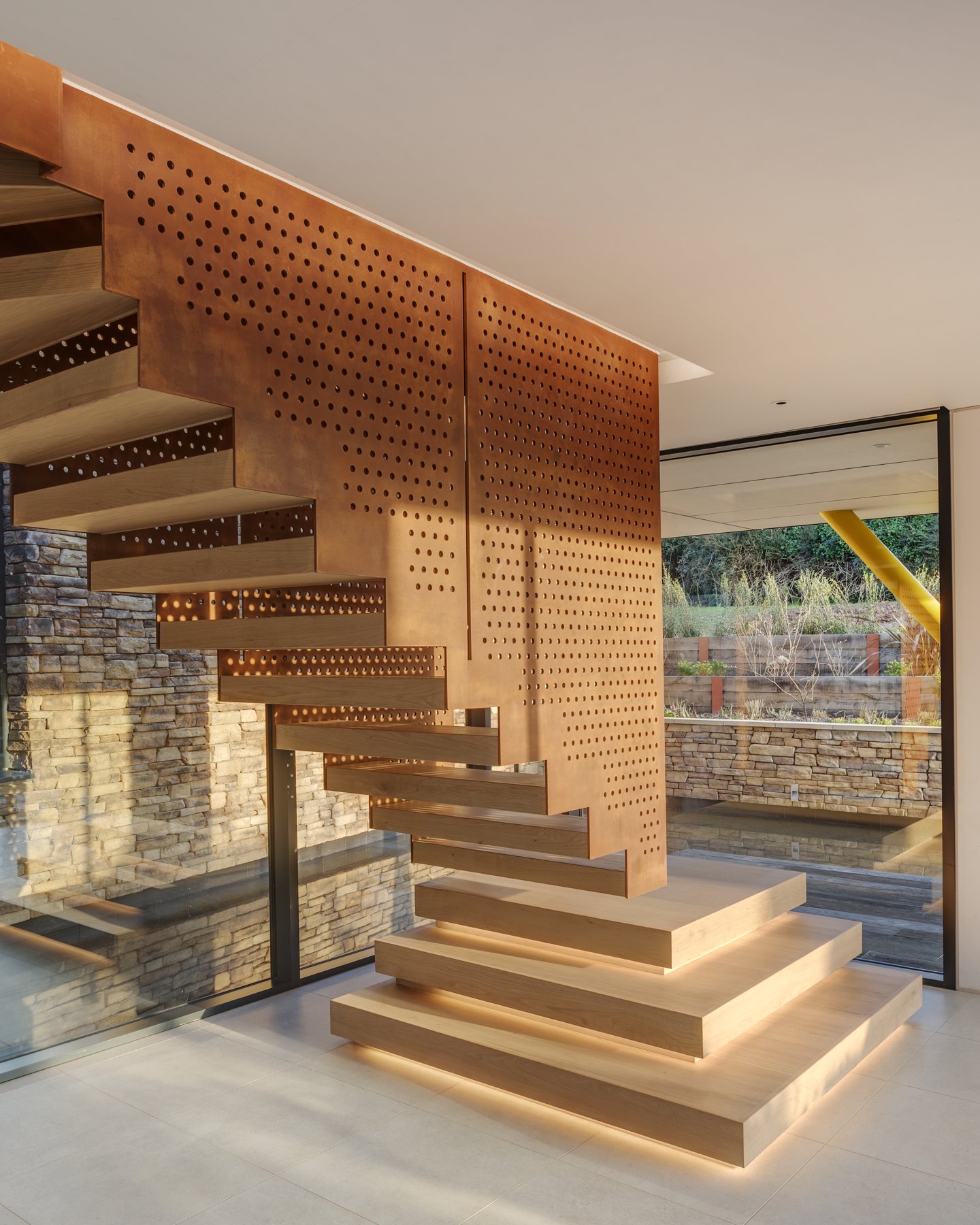 Timber staircase with integrated lighting and perforated metal balustrade